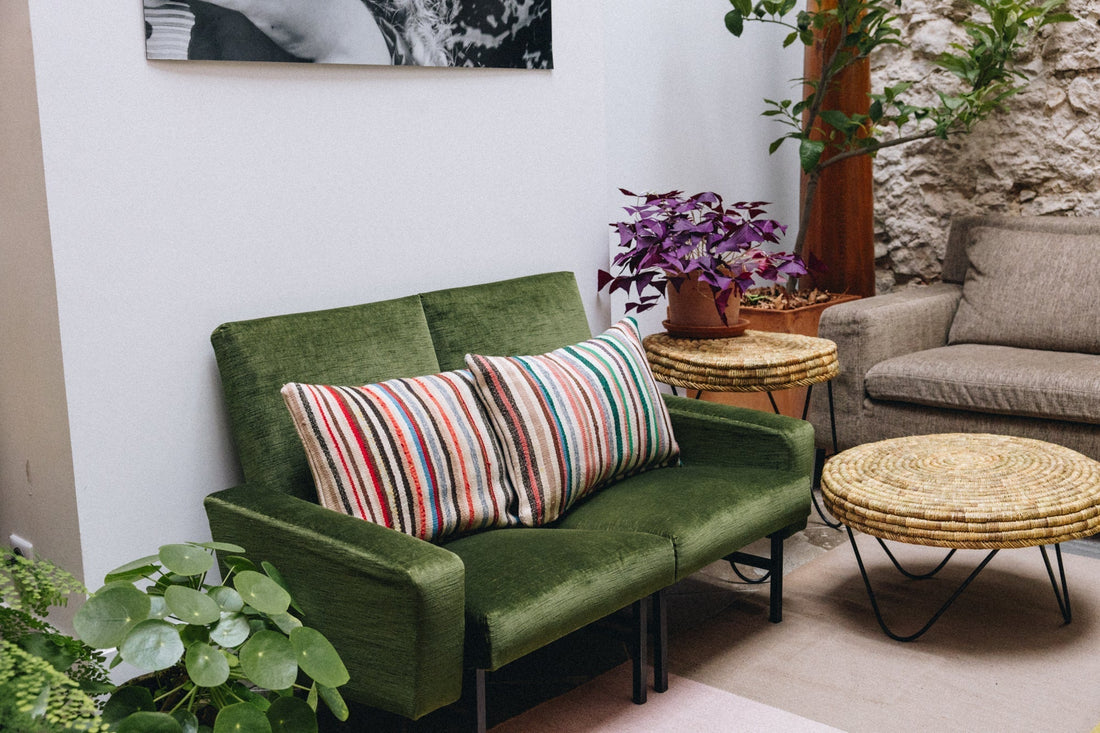 Salon avec coussins artisanaux sur canapé vert — déco bohème naturelle ZliZ