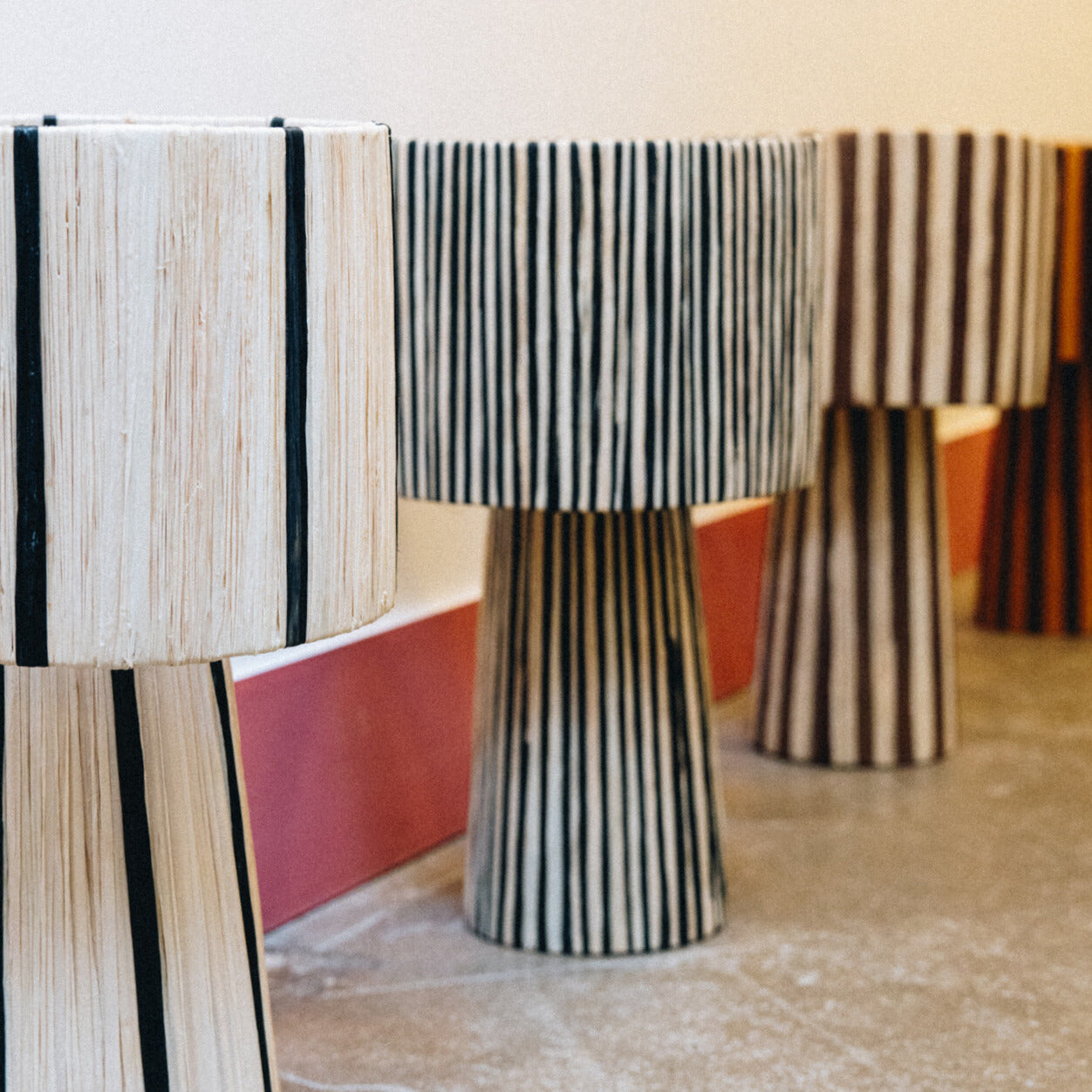 Des lampes et suspensions en raphia et fibres naturelles, entièrement façonnées à la main. Chaque pièce diffuse une lumière douce et chaleureuse, entre authenticité artisanale et élégance contemporaine.