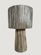 La lampe ILLA séduit par son design épuré et son raffinement artisanal.
Tissée à la main en raphia majoritairement noire, soulignée d’un léger filet de raphia naturel, elle diffuse une lumière douce et enveloppante, parfaite pour créer une atmosphère chic et apaisante.

Idéale sur une table d’appoint, une console ou en lampe de chevet, ILLA apporte une touche contemporaine et authentique à tout type d’intérieur.