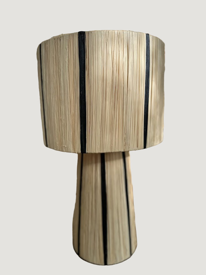 La lampe MALU incarne la simplicité raffinée et l’élégance naturelle.
Tissée à la main en raphia majoritairement naturel, rehaussée d’un fin filet noir, elle diffuse une lumière douce et chaleureuse, parfaite pour créer une ambiance cosy et apaisante.

Idéale en lampe de chevet, sur un buffet ou une console, MALU s’intègre harmonieusement dans tout intérieur bohème, contemporain ou ethnique chic.