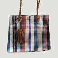 Né de la rencontre entre artisanat traditionnel marocain et design contemporain, le sac Aki est confectionné à partir d’anciennes couvertures Haïk, soigneusement chinées et transformées en pièces uniques.
Chaque sac se distingue par ses motifs, rayures et nuances, rendant chaque modèle absolument singulier.