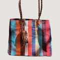 Né de la rencontre entre artisanat traditionnel marocain et design contemporain, le sac Aki est confectionné à partir d’anciennes couvertures Haïk, soigneusement chinées et transformées en pièces uniques.
Chaque sac se distingue par ses motifs, rayures et nuances, rendant chaque modèle absolument singulier.