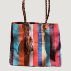 Né de la rencontre entre artisanat traditionnel marocain et design contemporain, le sac Aki est confectionné à partir d’anciennes couvertures Haïk, soigneusement chinées et transformées en pièces uniques.
Chaque sac se distingue par ses motifs, rayures et nuances, rendant chaque modèle absolument singulier.