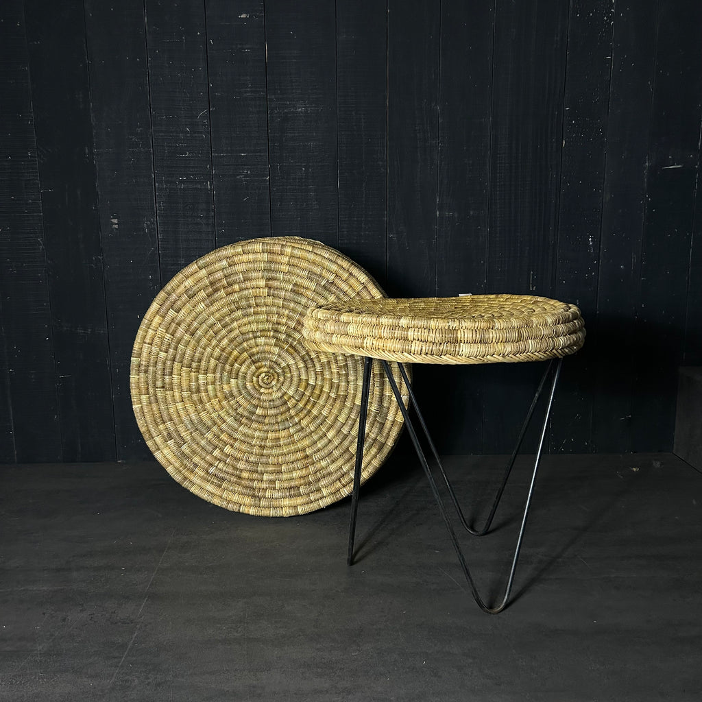 La table TAWU incarne la rencontre parfaite entre artisanat traditionnel et design contemporain.
Tressée à la main à partir de feuilles de palmier naturelles, chaque pièce révèle un travail minutieux et une texture organique unique. Son piètement en métal noir brut apporte une touche moderne et élégante, créant un contraste subtil et harmonieux.