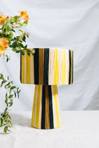 Apportez une touche de caractère et de douceur à votre intérieur avec la lampe AZGA, une pièce artisanale au design épuré et aux harmonies de couleurs naturelles.
Tissée à la main, en raphia, chaque lampe révèle un jeu de rayures exclusif, signature du savoir-faire artisanal ZliZ.