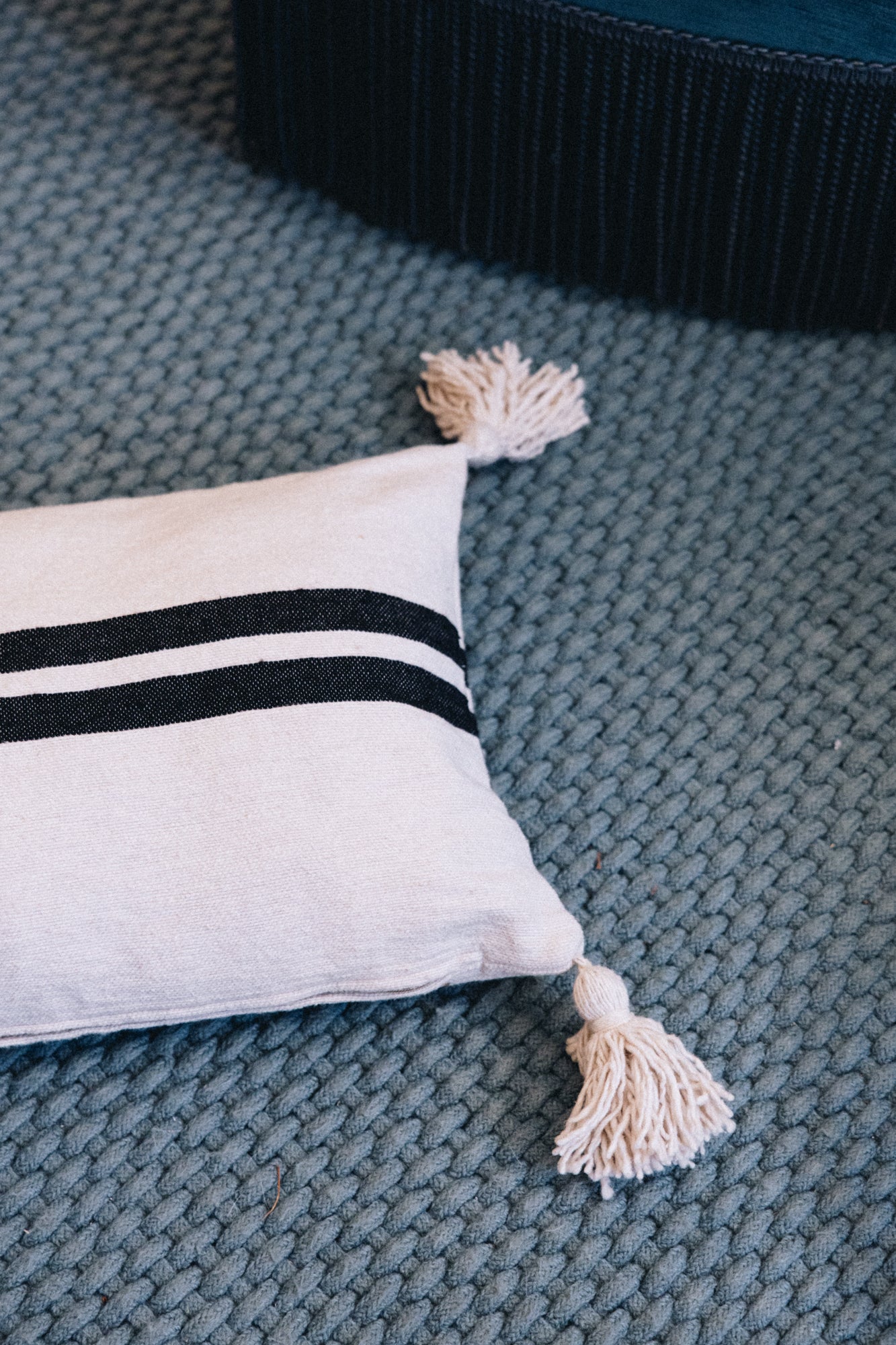 En coton brut tissé et confectionné à la main sur un métier traditionnel marocain, la housse IGRIZ séduit par son élégance épurée.
Ses rayures noires sur fond écru apportent une touche authentique et intemporelle à votre décoration.