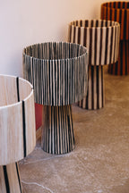 La lampe ILLA séduit par son design épuré et son raffinement artisanal.
Tissée à la main en raphia majoritairement noire, soulignée d’un léger filet de raphia naturel, elle diffuse une lumière douce et enveloppante, parfaite pour créer une atmosphère chic et apaisante.

Idéale sur une table d’appoint, une console ou en lampe de chevet, ILLA apporte une touche contemporaine et authentique à tout type d’intérieur.