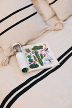 En coton brut tissé et confectionné à la main sur un métier traditionnel marocain, la housse ALMARE séduit par son élégance épurée.
Ses rayures noires sur fond écru apportent une touche authentique et intemporelle à votre décoration.