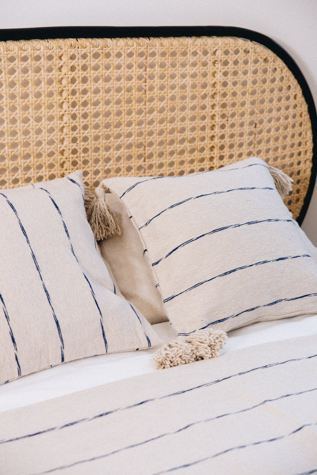 En coton brut tissé et confectionné à la main sur un métier traditionnel marocain, la housse INDI séduit par son élégance épurée.
Ses fines rayures indigo sur fond écru apportent une touche authentique et intemporelle à votre décoration.