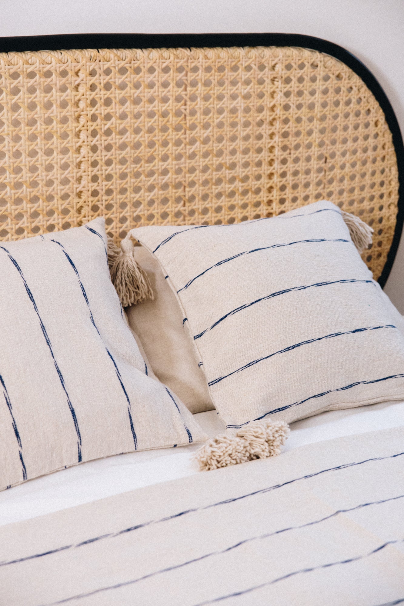 En coton brut tissé et confectionné à la main sur un métier traditionnel marocain, la housse INDI séduit par son élégance épurée.
Ses fines rayures indigo sur fond écru apportent une touche authentique et intemporelle à votre décoration.