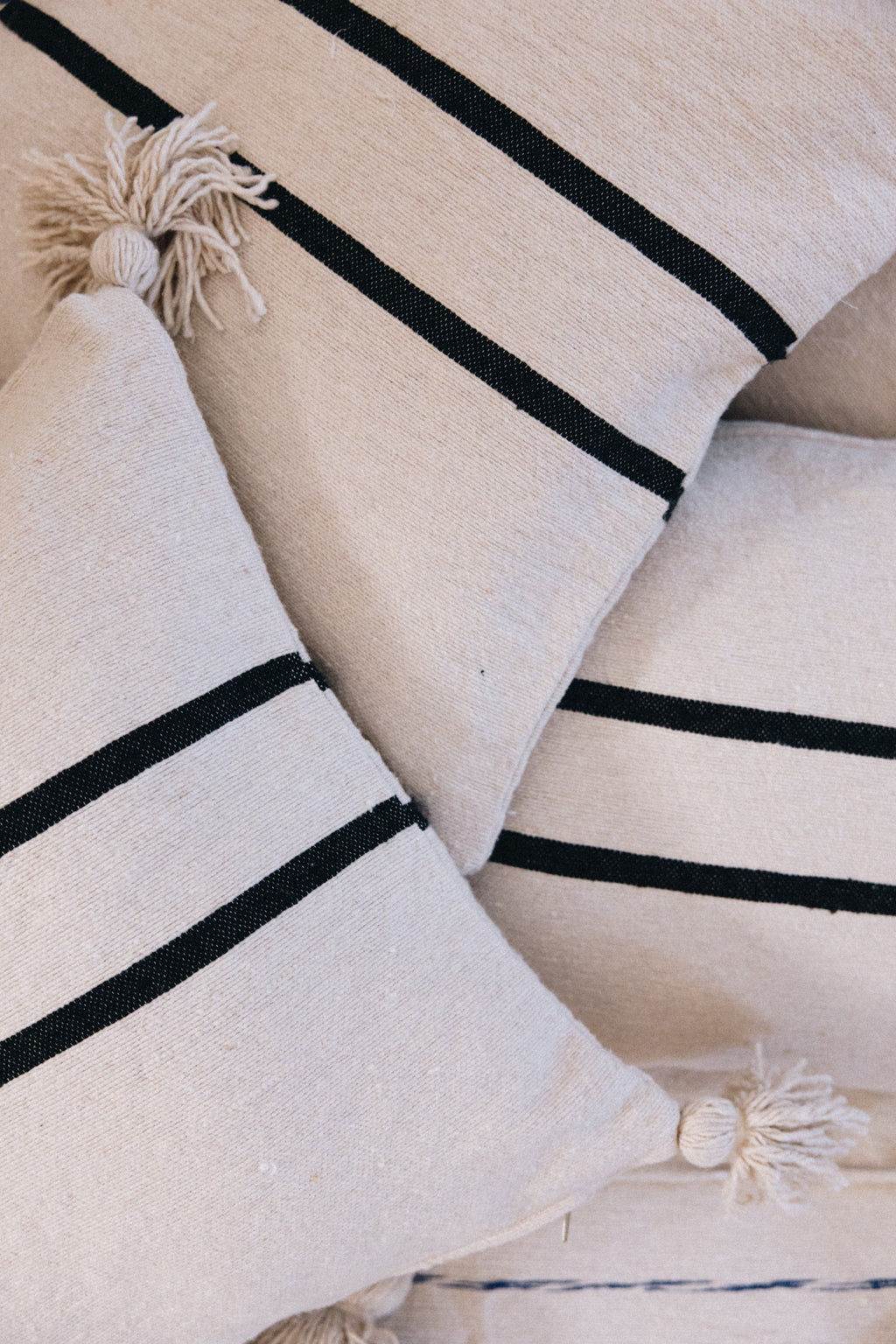 En coton brut tissé et confectionné à la main sur un métier traditionnel marocain, la housse ALMARE séduit par son élégance épurée.
Ses rayures noires sur fond écru apportent une touche authentique et intemporelle à votre décoration.