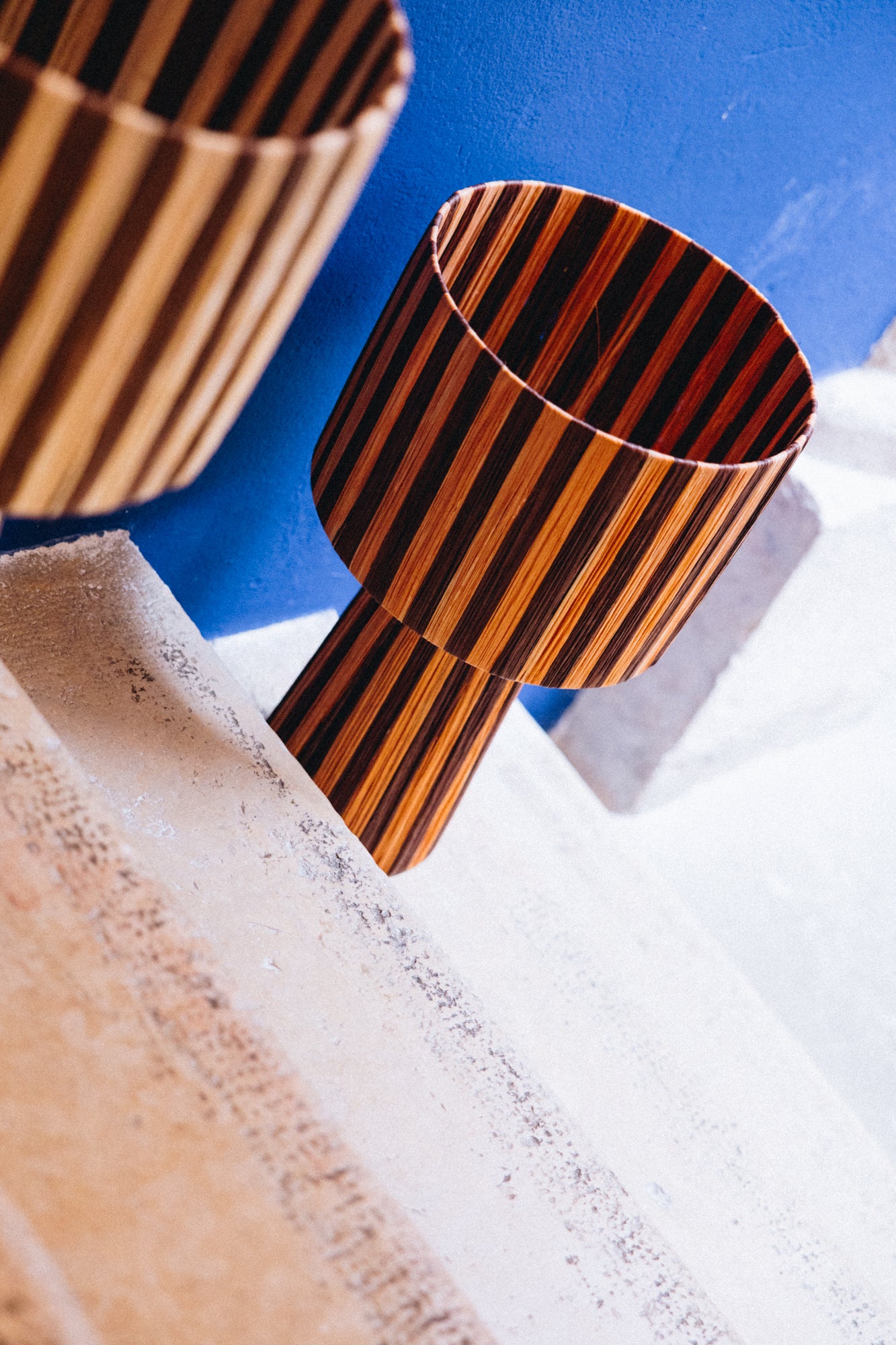 La lampe TERRA séduit par ses tons profonds d’orange et de cacao, qui diffusent une lumière douce et enveloppante.
Tissée à la main en raphia naturel, elle allie chaleur, authenticité et élégance contemporaine.