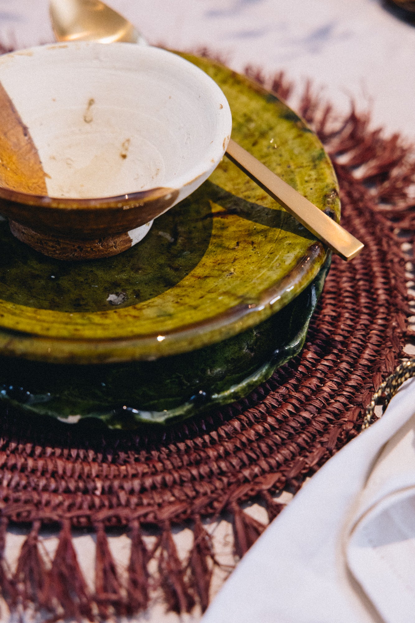 Façonné et émaillé à la main, le saladier AGA révèle un jeu de matières unique : une partie émaillée aux nuances ocre-vert, l’autre laissée volontairement brute, au naturel.