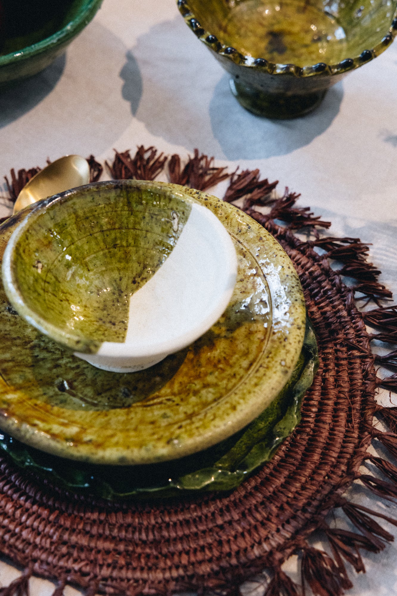 Façonné et émaillé à la main, le saladier AGA révèle un jeu de matières unique : une partie émaillée aux nuances ocre-vert, l’autre laissée volontairement brute, au naturel.