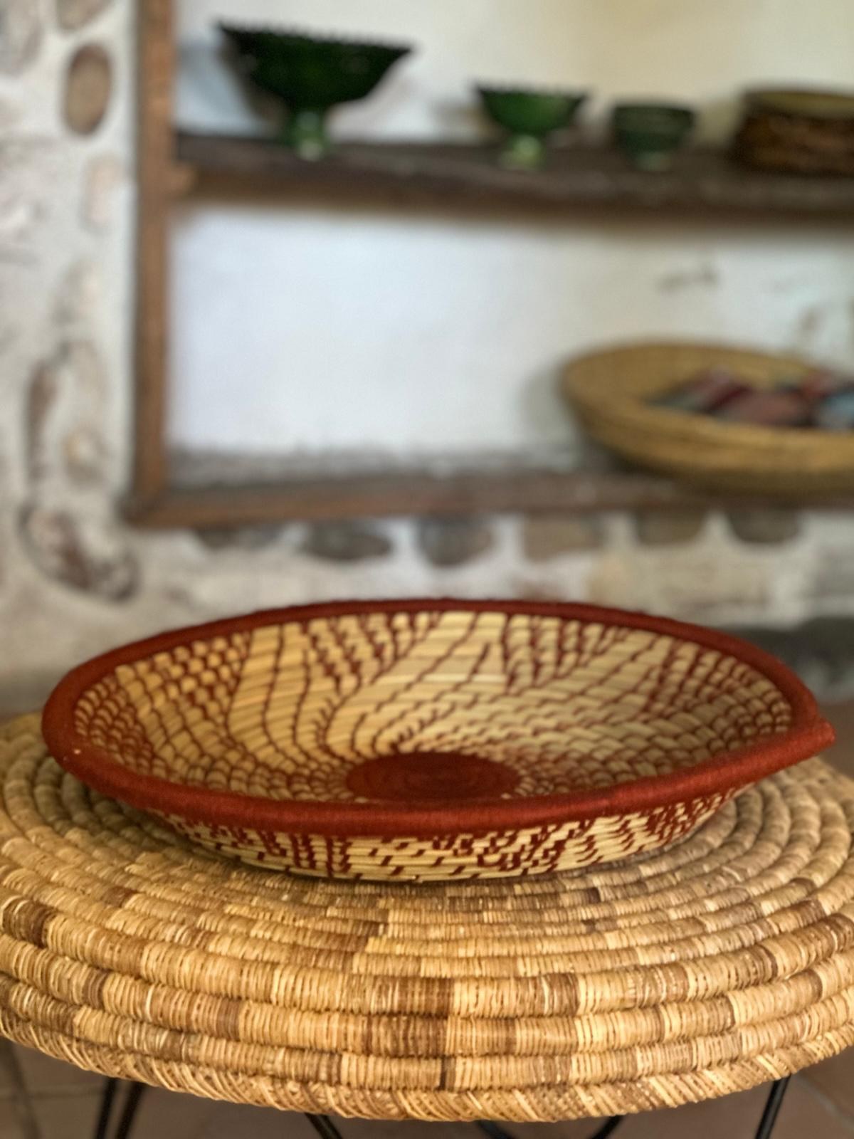 Plateau FLORA vu de profil, posé sur un guéridon tressé dans un intérieur en pierre