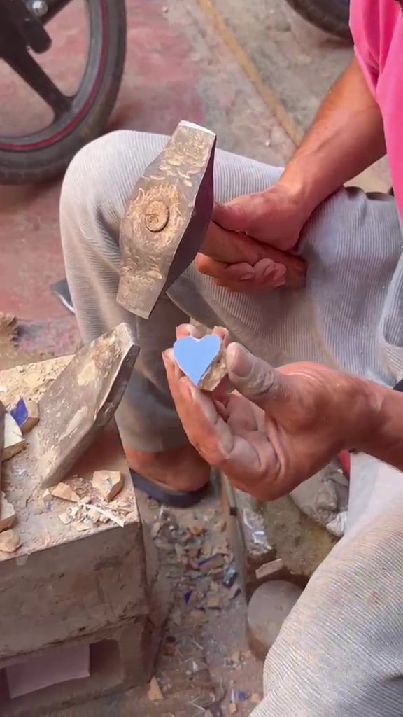 Artisan marocain montrant un cœur en zellige taillé à la main
